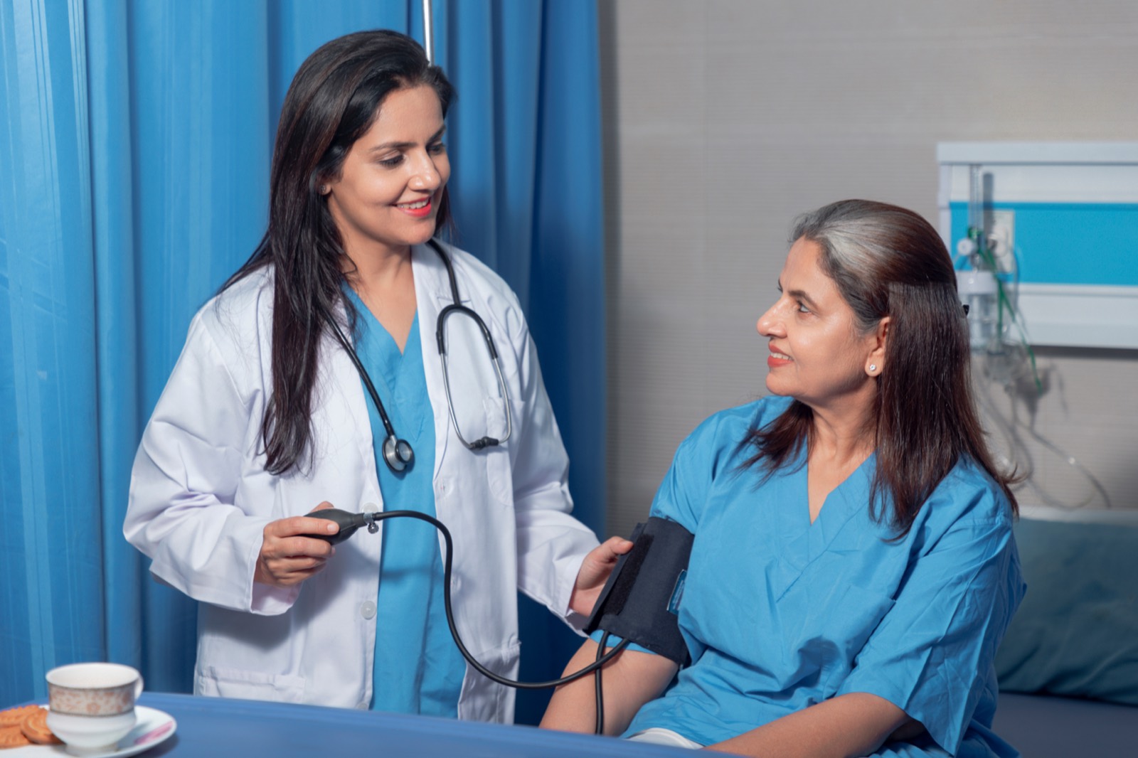 An Indian doctor checking on a senior patient in a clinic
